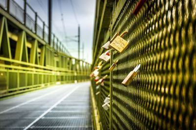 Close-up of love locks on railing at footbridge