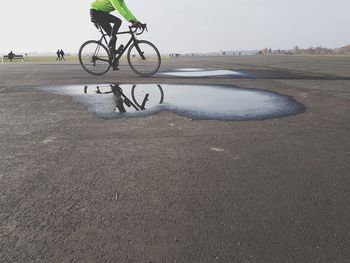 Man riding bicycle on road in city