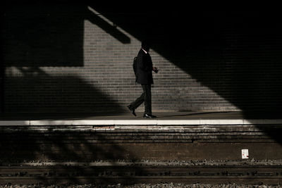 Side view of man walking on railroad station platform