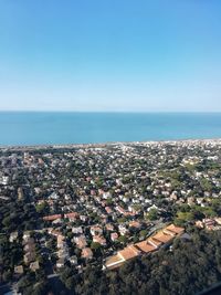 High angle view of buildings by sea against clear sky