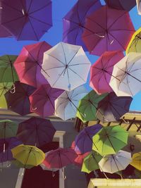 Low angle view of umbrellas hanging against sky