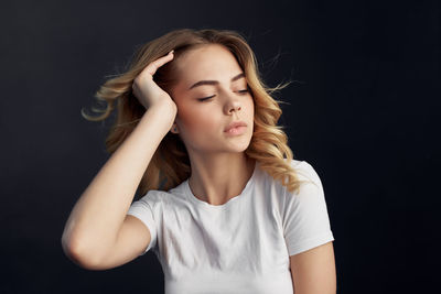 Portrait of beautiful young woman against black background