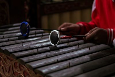 Midsection of man playing gamelan