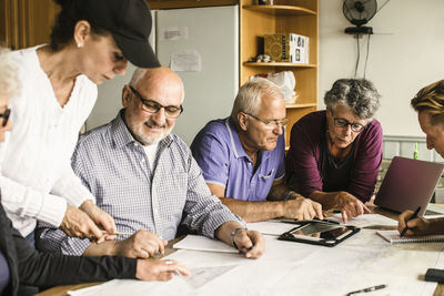 Senior men and women discussing at table during navigation course