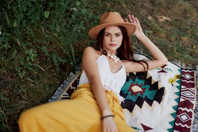 Portrait of young woman sitting on field