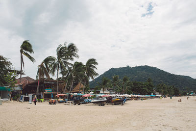 Panoramic view of people on beach against sky