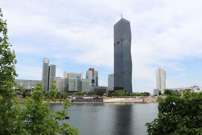 Buildings in city against cloudy sky