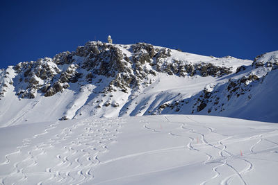 Snow covered mountain against blue sky