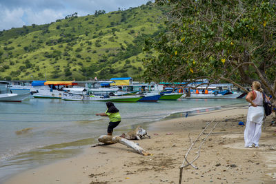 People on beach against mountains