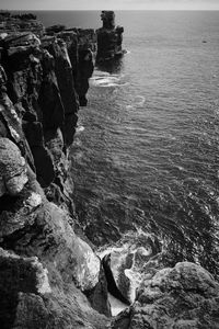 Rock formation in sea against sky