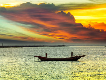 Silhouette boat in sea against sky during sunset