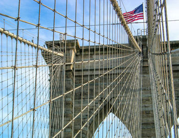 Low angle view of american flag waving on brooklyn bridge