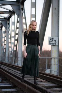 Full length of woman standing on railroad tracks