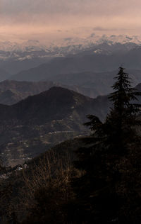 Scenic view of snowcapped mountains against sky at sunset