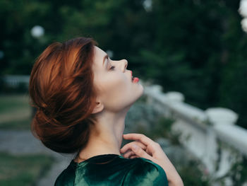 Portrait of a young woman looking up outdoors