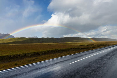 Rainbow and clouds at the side of the road in the fields of scenic rural iceland 