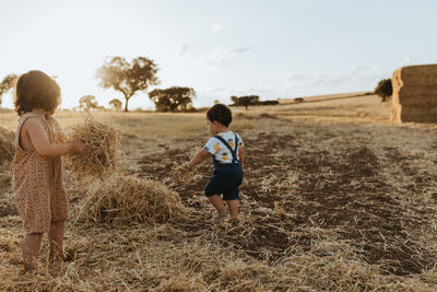 Brother and sister playing in the fields