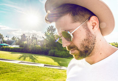 Close-up of man wearing sunglasses and hat at park