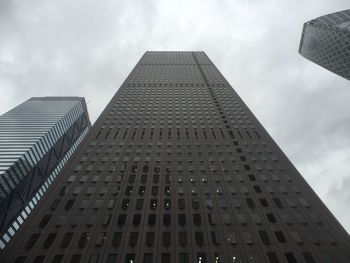 Low angle view of modern building against cloudy sky