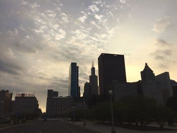 Buildings in city against cloudy sky