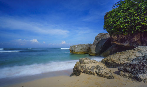 Scenic view of rocks on beach against sky