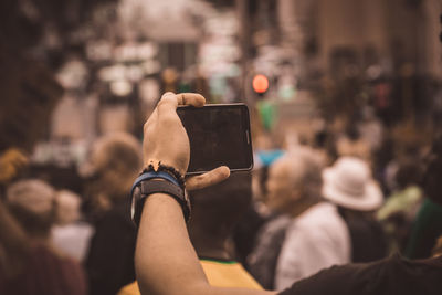 Close-up of woman photographing with mobile phone in city