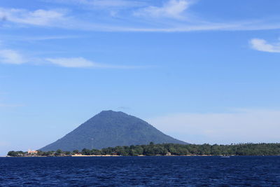 Scenic view of sea and mountains against sky