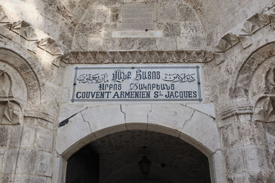 Low angle view of text on wall of historic building