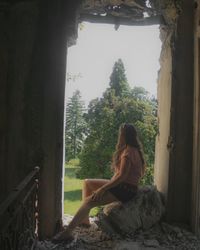 Woman looking through window