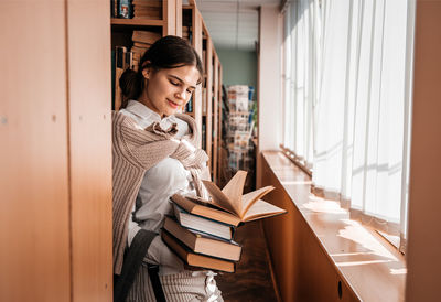 Young woman reading book at home
