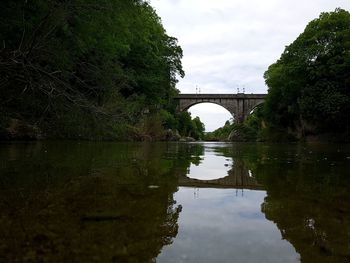 Arch bridge over river against sky