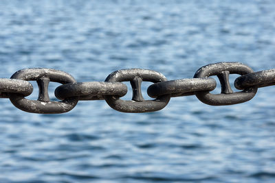 Close-up of chain against sea