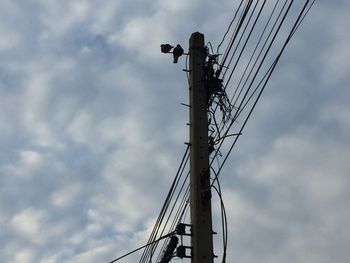 Low angle view of electricity pylon against sky