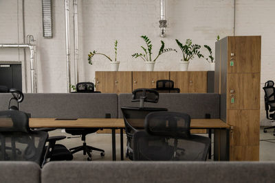 Interior of modern coworking space without people, containing tables and chairs.