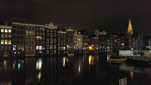 Reflection of buildings in calm water at night