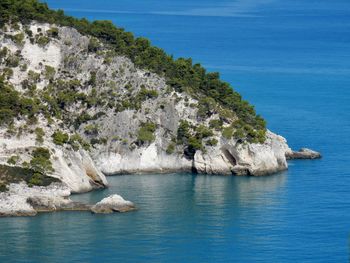 Scenic view of rocks in sea against blue sky