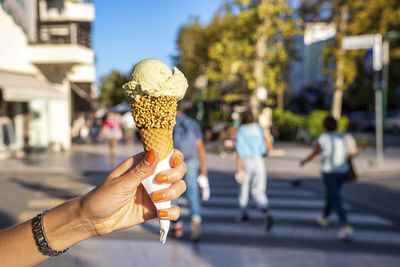 Hand of woman holding delicious chocolate gelato ice cream on city street