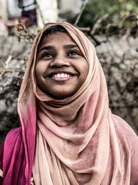 Smiling young woman in headscarf looking away