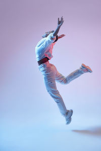 Low angle view of boy jumping against clear sky