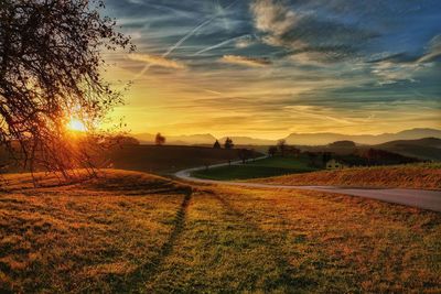 Scenic view of field against sky at sunset