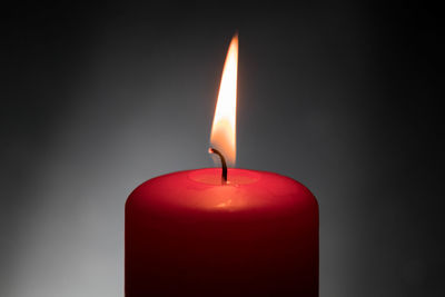 Close-up of lit candle against black background