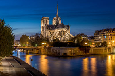 Illuminated notre dame de paris cathedral against sky at night