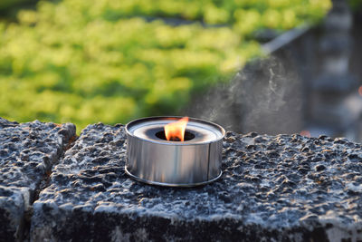 Close-up of light candles on rock