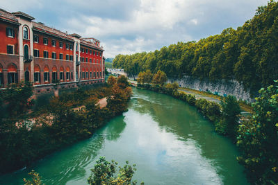 River amidst trees and buildings against sky