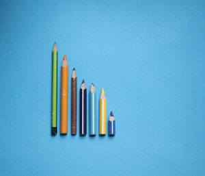 Close-up of colored pencils against blue background