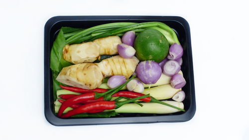 High angle view of vegetables on plate against white background