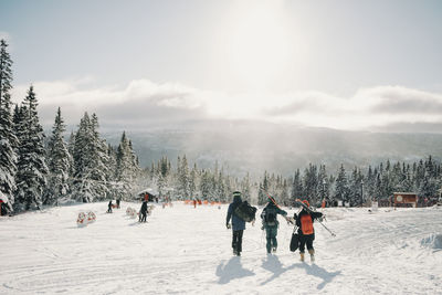 Male and female friends walking at tourist resort during winter