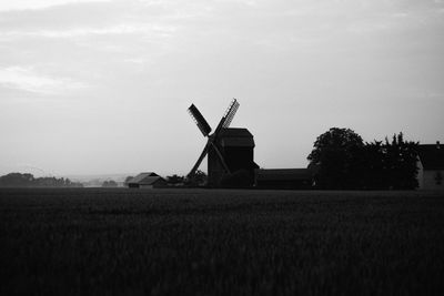 Traditional windmill on field against sky