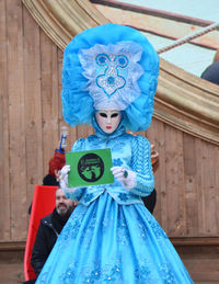 Full length of man wearing mask against blue wall