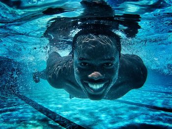 Portrait of smiling man swimming in pool